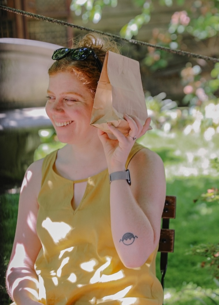 Ida Benedetto sitting in the sun in a yellow dress.